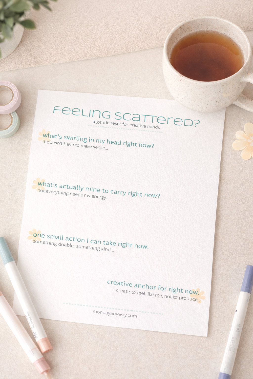 Sheet of paper titled 'Feeling Scattered?' on a table with a cup of tea and markers.
