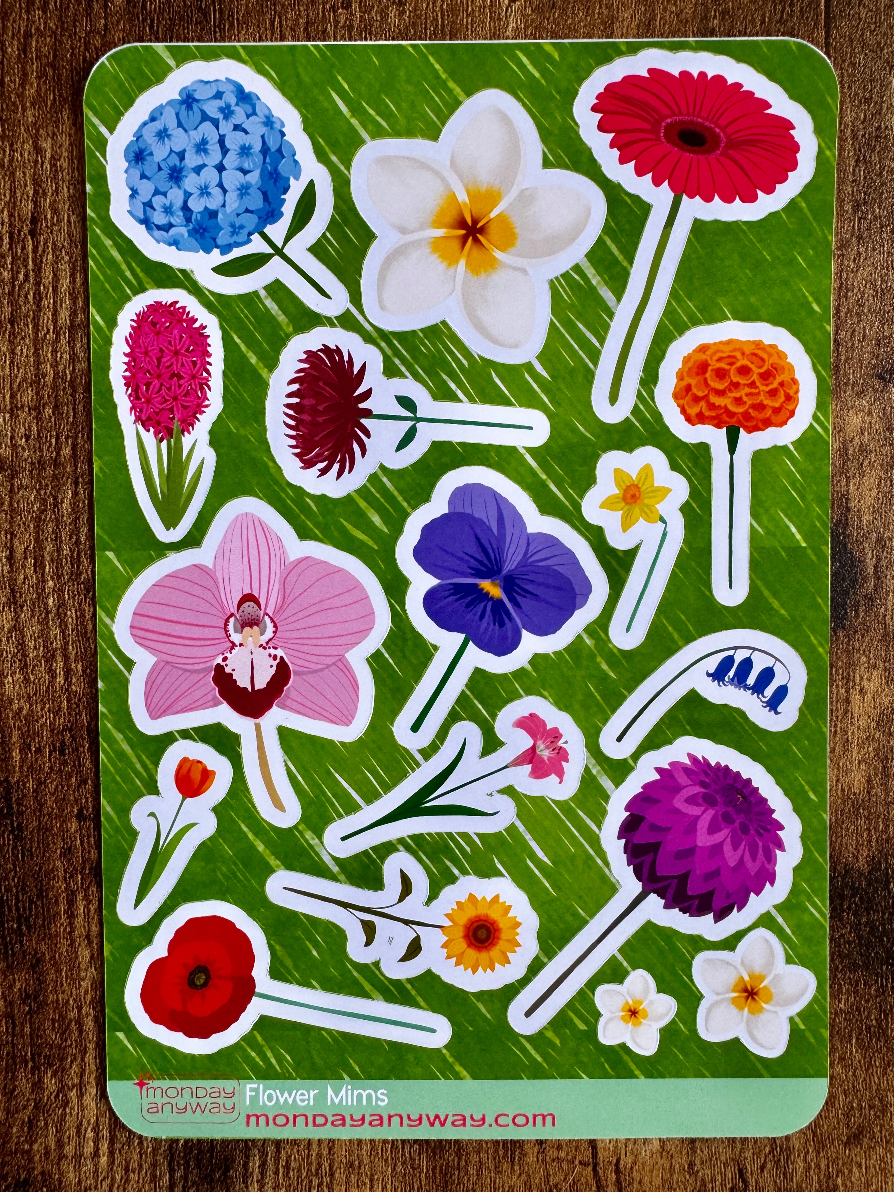 Sheet of colorful flower stickers on a green backing 