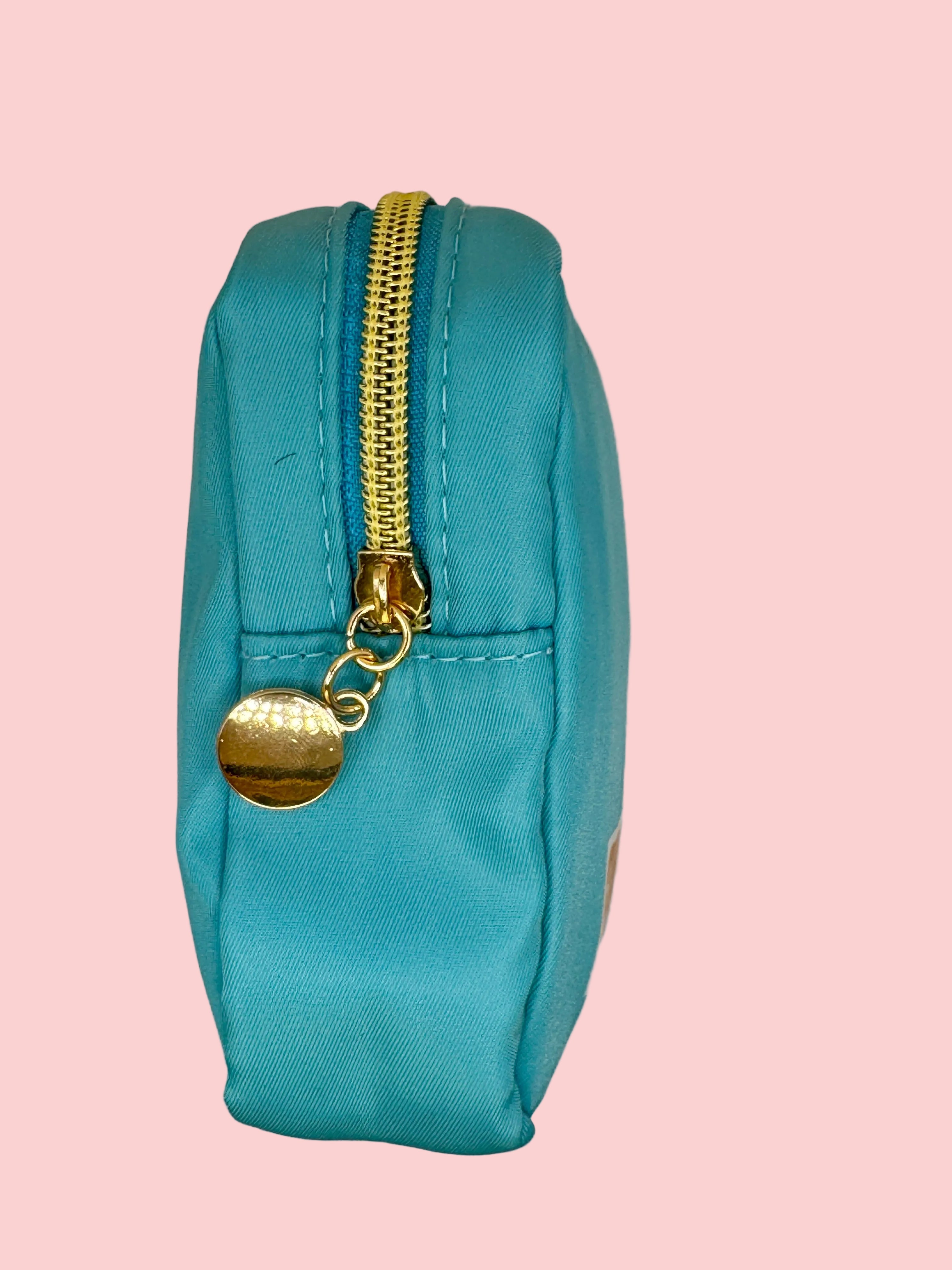 Turquoise pouch with a gold zipper and gold tag