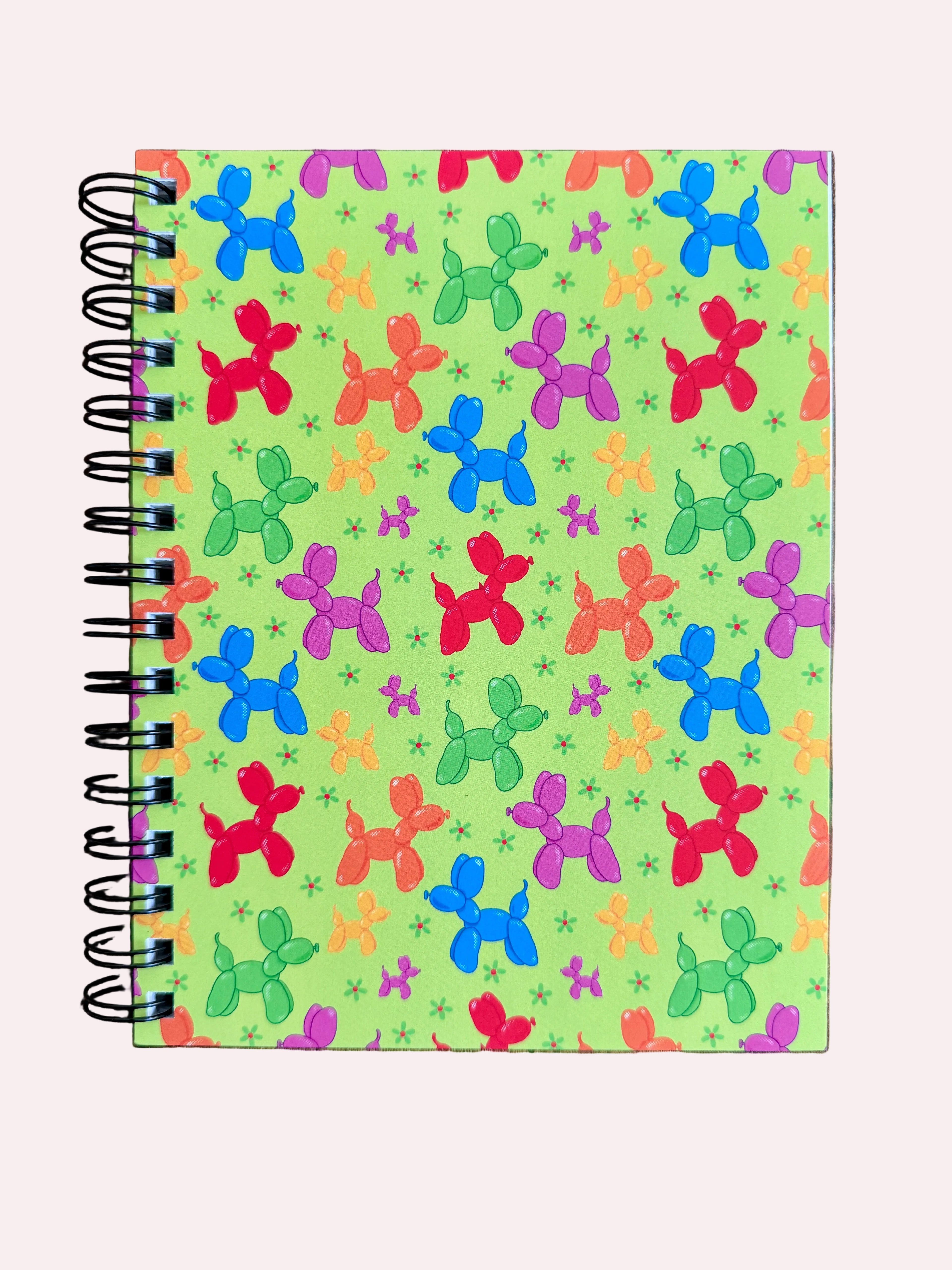 Notebook with colorful balloon dog pattern on a wooden surface