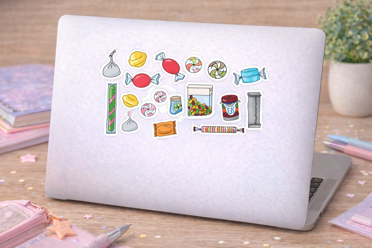 Laptop with candy-themed stickers on a wooden surface